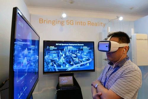 嘉賓在峰會現場利用VR設備觀看5G測試外場。
